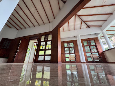 The veranda at V6 Nest with wooden window frames, chairs and a tiled floor